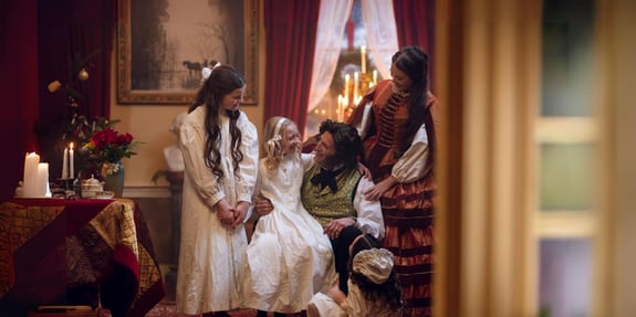 daughter sitting on fathers lap, family gathered