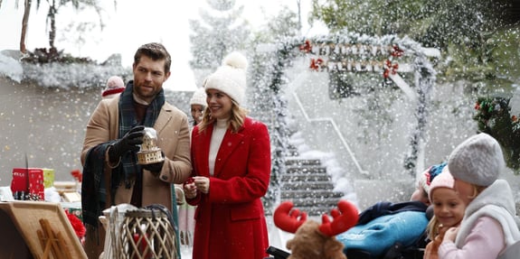 man and woman shopping at christmas market in snow