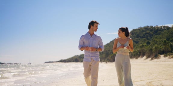 man and woman walking on beach prince in paradise