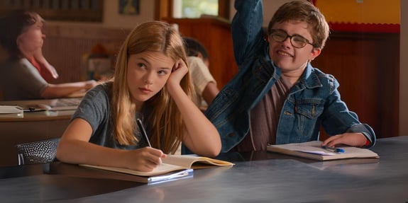 anna and michael shadrach raising hand at school desk