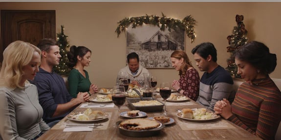 family at dinner praying tails of christmast